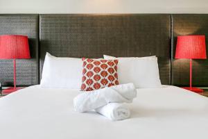 En eller flere senger på et rom på Darwin Harbourside Escape - Two Adjacent King Suites