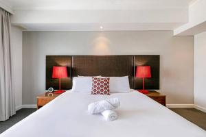 En eller flere senger på et rom på Darwin Harbourside Escape - Two Adjacent King Suites