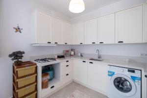 a kitchen with white cabinets and a washer and dryer at Villa with Balcony in Fethiye in Göcek