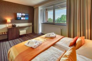 a hotel room with a bed and a window at Horizont Resort in Stará Lesná