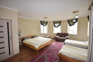 a bedroom with two beds and a rug at Riverside Karakol in Karakol