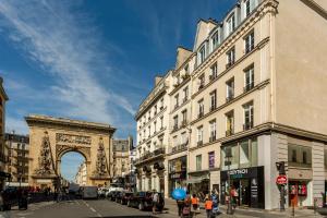 een stadsstraat met gebouwen en de Arc de Triomphe bij Cosy 2 bedrooms apartment with bathrooms - Louvre in Parijs