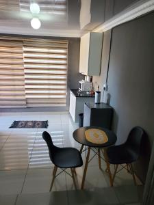 a small kitchen with a table and two chairs at Beloved Lodge in Kimberley