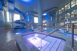 a large swimming pool with a slide in a building at Holiday Inn Express Hotel & Suites Erie - North East, an IHG Hotel in North East