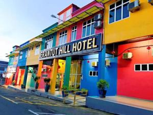 a hotel with a brightly colored facade on a street at JERANTUT HILL HOTEL in Jerantut