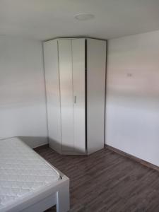 a bedroom with a white closet and a bed at Apartman ROKAN in Daruvar