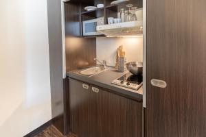 a small kitchen with a sink and a counter at Select Hotel Berlin The Wall in Berlin