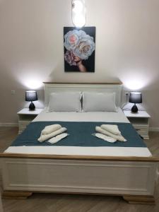 a bed with two pillows and a picture of roses at central square in Kutaisi