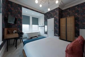 1 dormitorio con cama, lavabo y bañera en The Clarence Boutique Rooms, en Portsmouth