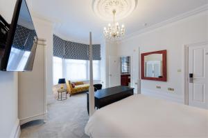 a bedroom with a bed and a chandelier at The Clarence Boutique Rooms in Portsmouth
