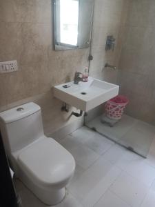 een badkamer met een wit toilet en een wastafel bij HOTEL THE AM BLISS in Gurgaon