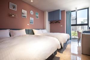 台南的住宿－河樂觀光旅宿，酒店客房设有两张床和窗户。