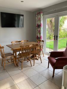 una sala da pranzo con tavolo e sedie in legno di Magheraboy Cottage Portrush a Portrush