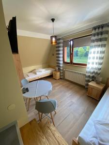 um quarto com uma mesa e cadeiras e uma cama em Noclegi 25 H em Zakopane