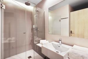 uma casa de banho branca com um lavatório e um chuveiro em B&B HOTEL Madrid Fuenlabrada em Fuenlabrada