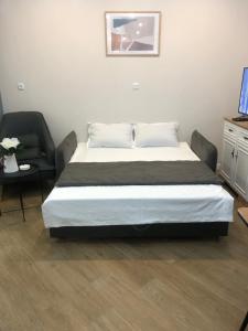 a bedroom with a large bed and a chair at central square in Kutaisi