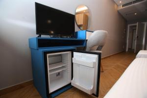 a desk with a tv and a small refrigerator at Diamond Hotel in Durrës