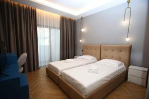 a bedroom with a large bed and a window at Diamond Hotel in Durrës