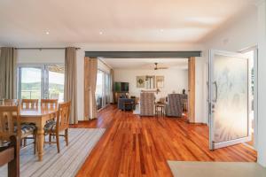 a dining room and living room with a table and chairs at Paradise on Ridge in Knysna
