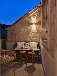 un pequeño patio con 2 sillas y una mesa en Apartment Tomazina (seaview,central, heritage), en Vis