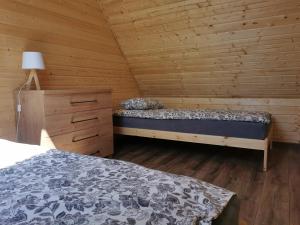 een slaapkamer met een bed in een houten hut bij NADMORSKI RESORT in Niechorze