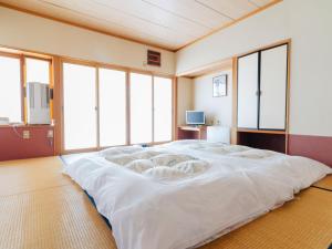 a large white bed in a room with windows at Oogute Kohan Shirasagi So in Shimojo mura