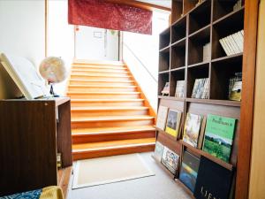 a staircase in a room with a book shelf at Oogute Kohan Shirasagi So in Shimojo mura