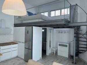 a room with a loft with a bed and a kitchen at Das blaue Haus in Castillo del Romeral