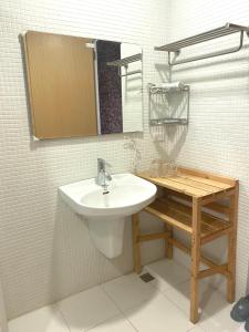 a bathroom with a sink and a mirror and a table at Er Jie's House in Tainan