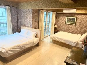 Habitación de hotel con 2 camas y ventana en Er Jie's House, en Tainan