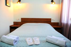 un dormitorio con una cama con dos pares de zapatillas en Janika apartments, en Tiflis 35 fotos más