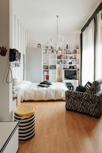 a white bedroom with a bed and a couch at Il Loggione in Enna