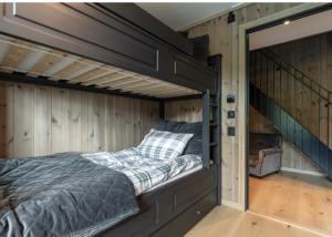 a bed in a room with wooden walls at Fantastic apartment in Hemsedal, ski in ski out, Fyri Tunet in Hemsedal
