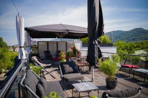 eine Terrasse mit Stühlen und einem Sonnenschirm auf einer Terrasse in der Unterkunft Qube Hotel Bergheim in Heidelberg