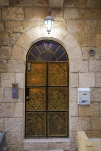Western Wall Luxury House في القدس: باب في مبنى حجري مع اضاءة فوقه