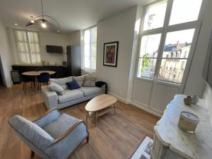 een woonkamer met een bank en een tafel bij Appartement Le Corneille centre ville climatisé in Saumur