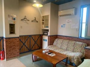 a living room with a couch and a table at Village BFH in Omura