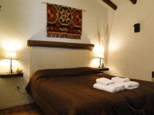 a bedroom with a bed with towels on it at Chalets, Cabañas Terramaría de Potrerillos in Potrerillos