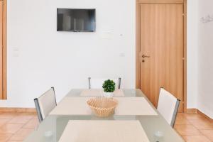 una sala da pranzo con tavolo, sedie e TV di Casa Mazzini a Matino