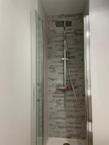 una doccia in un bagno con un muro in pietra di Idéalement situé, vue mer & Parking privée gratuit a Canet-en-Roussillon