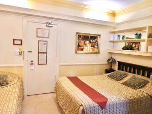 a bedroom with a bed and a door with a painting at Charrington Hotel in Sydney