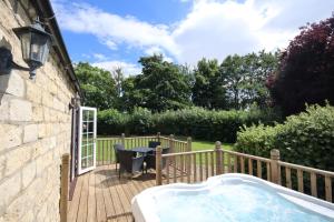 a hot tub on a deck next to a house at Barker Stakes Farm in Pickering