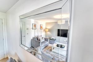 einen großen Spiegel im Wohnzimmer mit Sofa in der Unterkunft Guest Homes - Walkers Lane House in Worcester