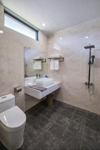 y baño con aseo blanco y lavamanos. en Sea Star Resort, en Dong Hoi