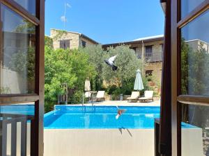 a bird is flying over a swimming pool at Eveleos Country House in Tochni