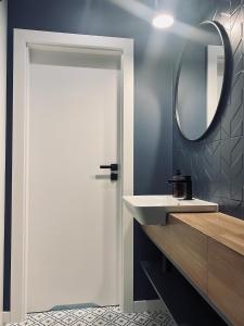 a bathroom with a white door and a sink at Apartament Family Premium - Baltic Sun Sztutowo in Sztutowo