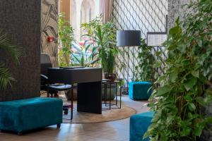a room with potted plants and a desk and a table at Hotel Memories Budapest in Budapest