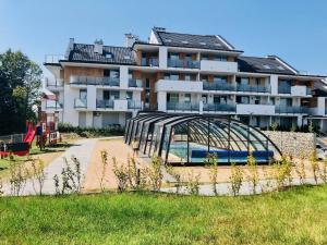 a large apartment building with a bridge in front of it at Apartament Family Premium - Baltic Sun Sztutowo in Sztutowo