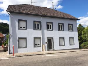 un edificio blanco al lado de una calle en Le Terramon - Appartement 4 personnes, en Orbey