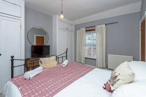 a bedroom with a large bed and a mirror at Beautiful Redbrick Home in Ruthin Centre & Parking in Ruthin